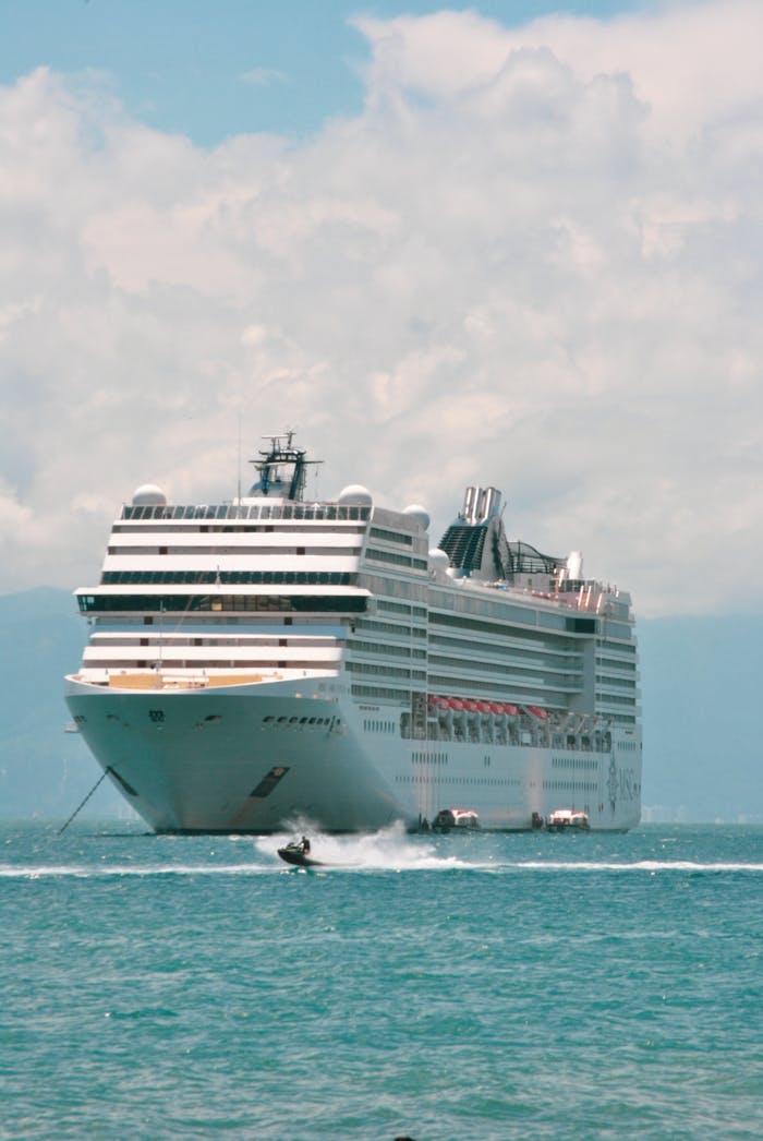 A grand cruise ship sailing the vast ocean, under a bright sky, symbolizing travel and maritime adventure.